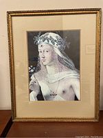 Full view of framed vintage print showing an ornate gold frame, double matting, and the subject within.