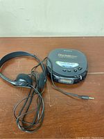 Top view of Sony Discman ESP D-247 showing model name, control buttons, protective sticker and headphones connected.