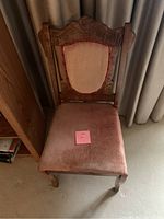 Full view of a single wooden chair with red velvet upholstery on seat and backrest, detailed carved wooden frame visible.