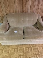Front view of beige 63 inch love seat showing fabric texture, button tufted back, and removable seat cushions