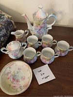 Full view of the Nippon tea set including teapot, creamer, sugar bowl, six cups, and plate on a wooden surface.