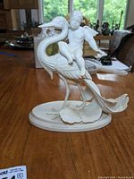 Front view of figurine showing Cupid seated on heron with base