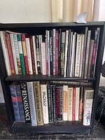 Full view of black two-shelf bookcase filled with books