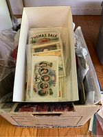 Box containing various vintage cigar box stickers and ephemera including Thomas Dale labels.