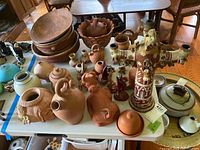 Overall table view of unglazed terracotta and glazed pottery assortment