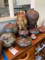 View of nine earthenware vessels on wooden surface