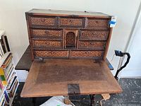 Front view with fold-down writing surface open revealing nine inlaid drawers