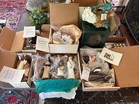 Set of nine biblical figurines in boxes with bubble wrap, alongside description cards. One angel figurine visible on green box.