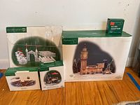 Photo of all boxed items showing Big Ben building, Ice Crystal gate and walls, Lord and Taylor Flower Cart, wooden rowboats, and AC/DC adapter.