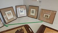 Photo showing the four metal framed Egyptian zodiac prints arranged against wall, varying frame size 9-10.5 inches.