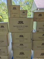 Boxes of Heritage Village Collection porcelain figurines and accessories stacked together, showing multiple item boxes including Christmas in the City series and others.