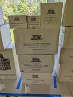 Stacked boxed items from Heritage Village Collection showing the different sets in the lot including Christmas in the City series and porcelain accessory sets