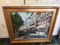 Full view of framed canvas artwork leaning against wall