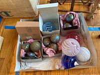 Overview of vintage blown glass Christmas ornaments in boxes and loose, showing different colors and swirl patterns