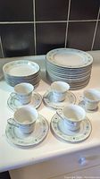 Full set arranged showing plates stacked, bowls stacked, and tea cups on saucers.