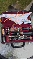 Jupiter clarinet disassembled in red velvet-lined case with cleaning cloth and cork grease