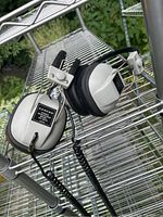 Pair of Lloyds stereo headphones model YH6473 with silver and black ear cups on metal shelving outdoors