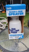 Front view of the Smith Bleach and Chem Sprayer in box showing the sprayer bottle and pump handle.