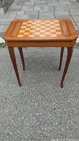 Full front view of the vintage wooden game table showing the inlaid chess and checkers board and tapered legs.