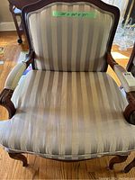 Front view of one armchair showing striped seat cushion and upholstery detail