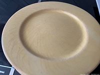 Close-up of yellow ceramic plate showing surface crazing and wear.