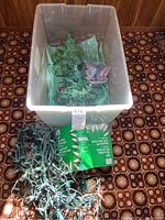 Two ceramic Christmas trees laid inside the container for better visibility, one tree has small colored light bulbs inserted and the other has no bulbs but a visible chip