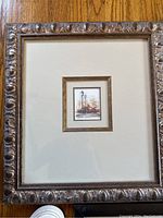 Small framed watercolor or ink architectural picture with gold-tone ornate frame and broad off-white matting.