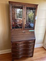 Full view of the wooden secretary desk dresser showing four curved drawers and glazed cabinet doors on top.