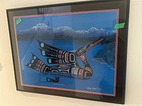Framed art print of a stylized bird with blue mountainous background and red, black indigenous design, one of three in lot