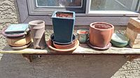 Full set of five ceramic planters and various ceramic, plastic, and glass trays displayed on an outdoor wooden shelf.