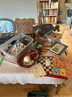 Overall view of table with games, books, Pokemon cards, and various items in bins and baskets