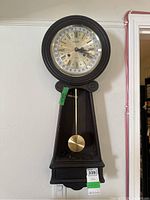 Full view of the Citizen wall clock showing the pendulum and wooden frame.