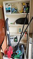 Photo of shelf with assorted garden and automotive maintenance items including Toro blower, string trimmer, and clippers.