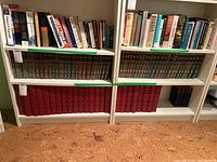 Wide view of shelves holding multiple books including the Britannica Great Books of the Western World in red and brown bindings on the bottom two shelves
