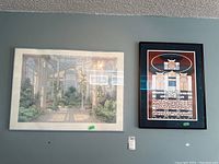 Two framed prints hanging side by side on a wall, left print is garden scene by Arthur Byrne, right print is contemporary London art with geometric design