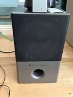 Front view of one Altec Lansing speaker showing black grille and silver lower section with bass port and Altec Lansing logo.