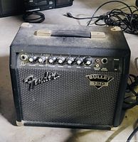 Front view of black Fender Bullet 150 amplifier with all control knobs visible and power switch on.