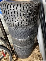 Stack of 5 golf cart tires showing tread patterns and sidewalls.