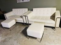 Front view of two loveseats and two ottomans