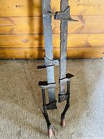 Two older metal wood clamps approximately 3 feet long, showing surface rust and wear, with wooden handles.