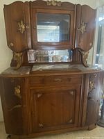 Front view of the antique French china cabinet showing upper glass cabinet, two side carved wooden doors, and lower cabinet with floral carved details and marble top