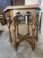 Antique hexagonal wooden parlor table showing top and decorative apron with turned legs and stretcher base.