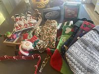 Overview of Christmas stockings, apron, hanging decor, puzzle box, and Yule glass box on table