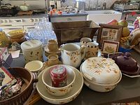 Overview of multiple items including covered casserole dish, pitchers, ceramic bowls, wooden tray, and two framed autumn-themed prints.