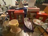 Wide shot of the collection showing multiple boxed and loose decorative figurines and ornaments including Fitz & Floyd and Franz items