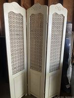Full view of the vintage 3-panel folding screen with off-white wood framing and fabric lace insets.
