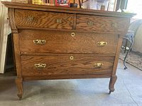 Front view of the oak Victorian dresser showing three large drawers and two smaller top drawers with brass hardware and wood grain details.