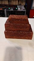 Three stacked rectangular wooden jewelry boxes, hand carved with floral patterns.