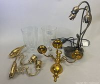 Vintage brass wall sconces with glass shades, and 3-light tulip lamp with brass lily pad base shown from various angles.