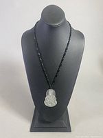 Full view of the necklace displayed on a bust stand, showing the pendant and beaded chain.